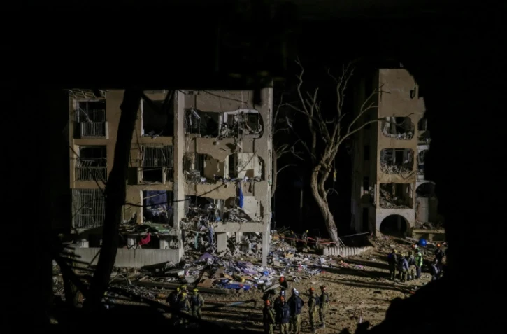 Des secouristes sur le lieu d'une frappe de missile iranien à Arad, en Israël, le 22 mars 2026