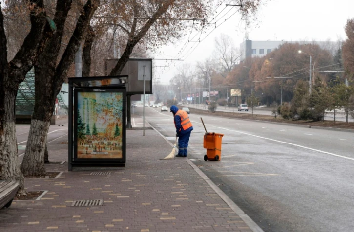 Un employé municipal balaie une rue d'Almaty le 10 janvier 2022 après de violentes manifestations