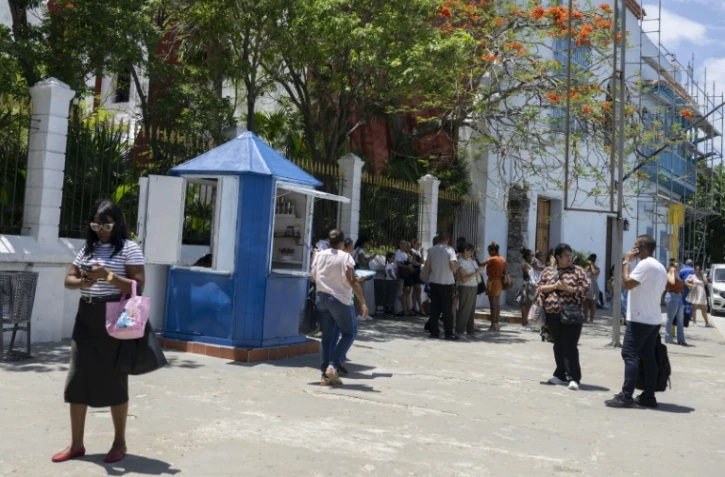Des employés attendent dans la rue après avoir évacué leurs bureaux après des secousses provoquées par un séisme de magnitude 6,5 à La Havane, le 8 juin 2026 à Cuba