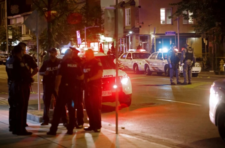 Des policiers de Toronto dans Danforth Street, sur la scène de la fusillade qui a fait deux morts, le 23 juillet 2018