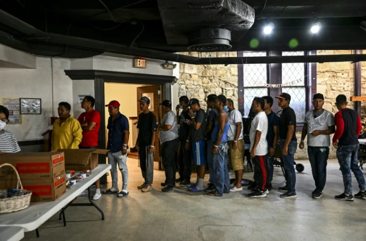 Des migrants font la queue pour une distribution de repas dans un refuge à San Antonio, le 29 juin 2022 au Texas