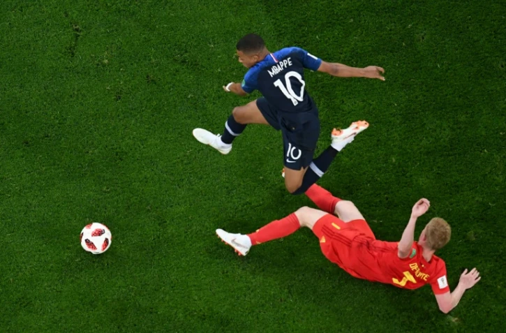 L'attaquant français Kylian Mbappé (g) à la lutte avec le Belge Kevin De Bruyne lors de la demi-finale, à Saint-Pétersbourg, le 10 juillet 2018
