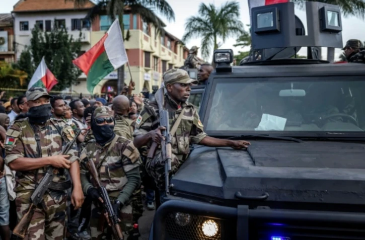 Des soldats malgaches en véhicules blindés sont entourés de manifestants saluant leur arrivée à l'hôtel de ville d'Antananarivo, le 11 octobre 2025 ( AFP / Luis TATO )
