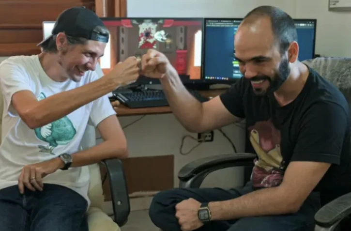 Les développeurs Josuhe Pagliery (G) et David Darias (D) se congratulent après la sortie sur les consoles et plateformes internationales de "Saviorless", le premier jeu vidéo cubain indépendant, à La Havane, le 2 avril 2024 ( AFP / ADALBERTO ROQUE )