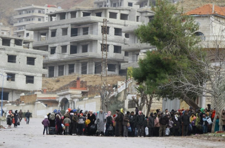 Des habitants de la localité assiégée de Madaya attendent un convoi d'aide de la Croix-Rouge syrienne, le 14 janvier 2016