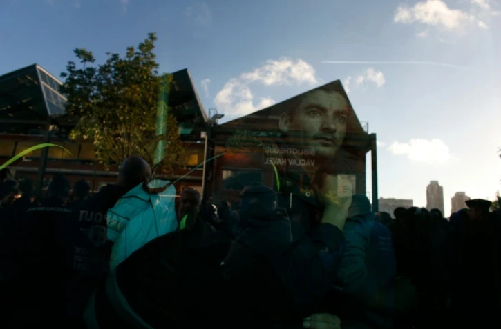 Un migrant regarde à travers la vitre du bus qui l'évacue du camp de migrants installé à la halle Pajol, le 29 juin 2016 à Paris