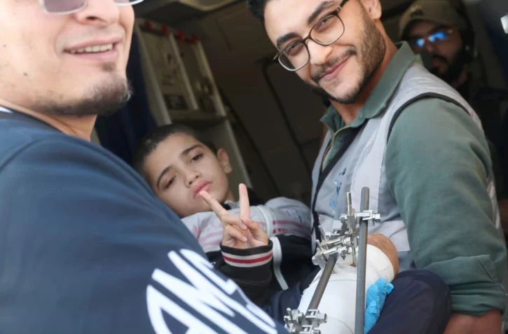 Des bénévoles sortent un enfant palestinien blessé d'un l'avion à Abou Dhabi, après avoir été évacué de la bande de Gaza dans le cadre d'une mission humanitaire organisée par les Emirats arabes unis, le 18 novembre 2023