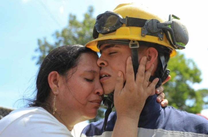 Un mineur secouru embrasse un de ses proches après être sorti d'une mine effondrée à Segovia, en Colombie, le 24 septembre 2025 ( AFP / JAIME SALDARRIAGA )