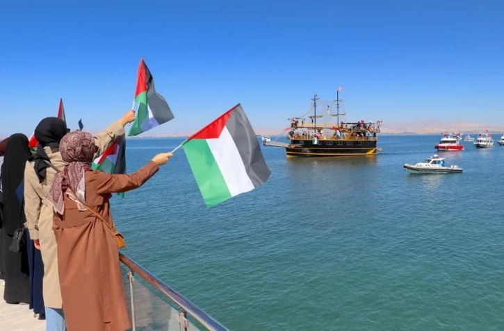 Des sympathisants saluent le passage de bateaux de la Flottille pour Gaza, le 5 octobre 2025, à Van (Turquie). (EMRE ILIKAN / ANADOLU / AFP)