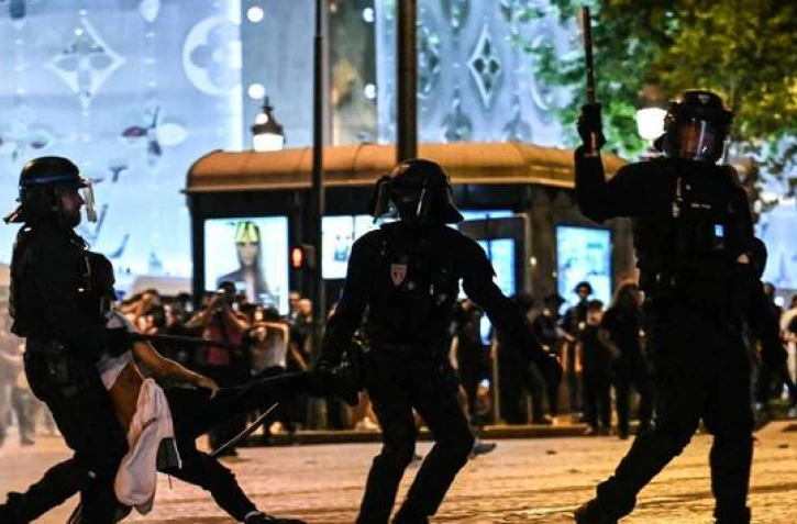 Des policiers anti-émeutes interpellent un supporter du PSG sur l’avenue des Champs-Élysées, samedi 31 mai 2025. | LOU BENOIST / AFP