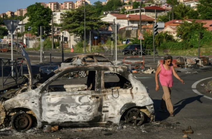 Des carcasses de voitures brûlées à Fort-de-France, le 23 septembre 2024 en Martinique ( AFP / Ed JONES )