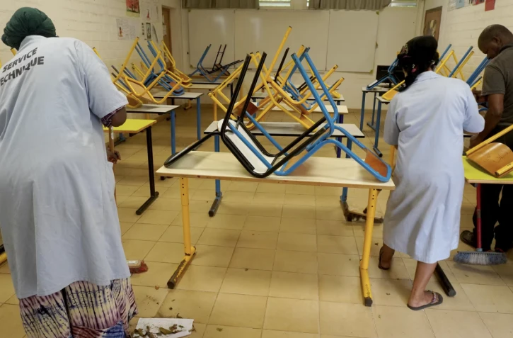 Des personnes nettoient une salle de classe dans une école de Dembeni, à Mayotte, le 22 janvier 2025. (MARINE GACHET / AFP)