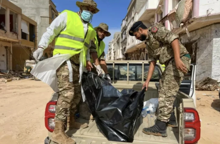 Les secours transportent un corps retrouvé dans les décombres de la ville de Derna, dans l'est de la Libye, le 17 septembre 2023. ( AFP / Abu Bakr AL-SOUSSI )