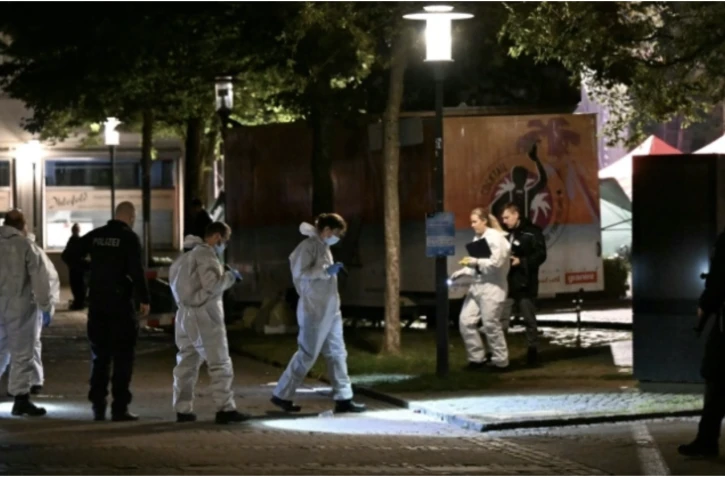 Un policier devant un véhicule de la Croix-Rouge le 24 août 2024 à Solingen, dans l'ouest de l'Allemagne, après une attaque meurtrière au couteau