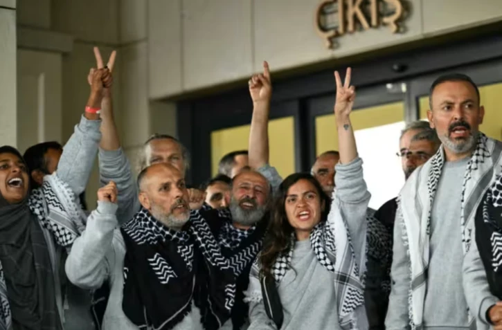 Des militants de la "flottille pour Gaza", arrêtés et expulsés par Israël, devant un terminal après leur arrivée à l'aéroport d'Istanbul, le 21 mai 2026 en Turquie ( AFP / Ozan KOSE )