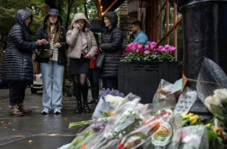Des personnes viennent rendre hommage à l'acteur Matthew Perry devant "l'immeuble" de la série "Friends" à New York, le 29 octobre 2023. ( AFP / Adam GRAY )