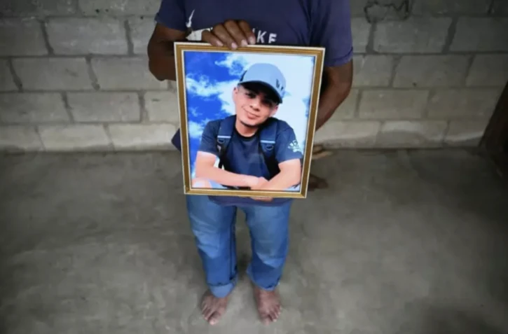 Manuel Rojche, le père du migrant guatémaltèque Francisco Rojche, décédé dans l'incendie du centre de rétention mexicain de Ciudad Juarez, tient son portrait de son fils dans la maison failiale de Siete Vueltas, au Guatemala, le 3 avril 2023 ( AFP / Johan ORDONEZ )