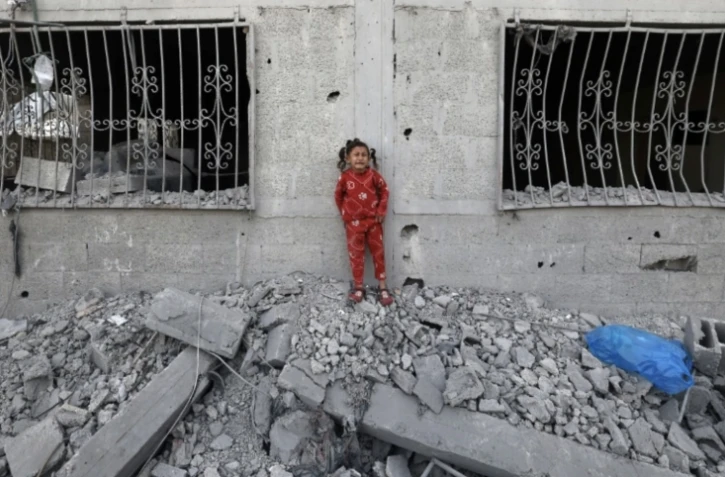 Une fille palestinienne pleure au milieu des débris près d'une maison touchée lors de frappes israéliennes à Khan Younès, dans le sud de la bande de Gaza, le 2 avril 2025 ( AFP / Eyad BABA )
