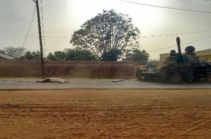 Un corps recouvert et un blindé dans une rue de El-Geneina, la capitale de l'Etat du Darfour-Ouest, au Soudan, le 16 juin 2023