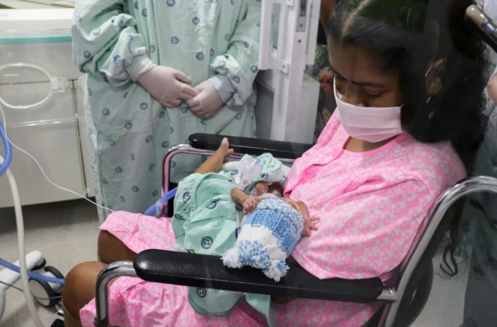 Diana Angola, atteinte par le coronavirus, tient dans ses bras son fils Jefferson Ă la clinique de Versalles, le 23 juin 2020 Ă Cali, en Colombie