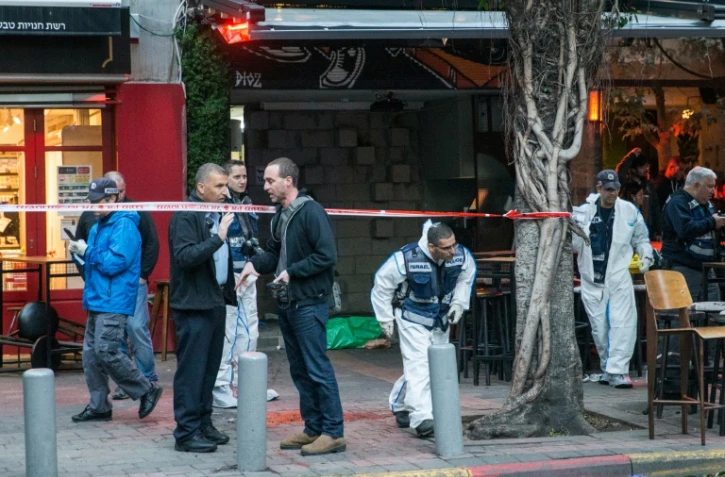 Des experts de la police scientifique isréalienne travaillent près d'un pub où un homme a ouvert le feu à tel Aviv le 1er janvier 2016