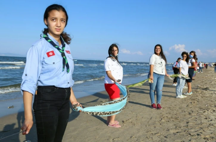 Des Tunisiens forment une impressionnante chaîne humaine sur cinq plages de la banlieue sud de Tunis pour protester contre la pollution marine le 12 septembre 2021