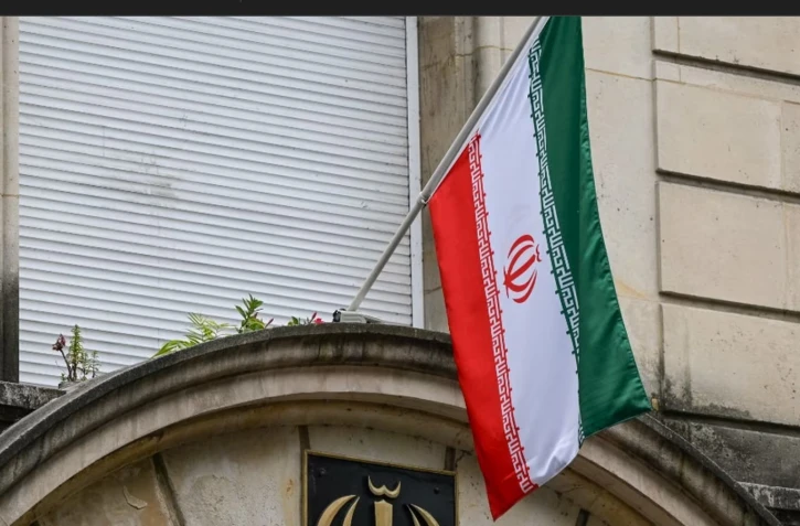 Un drapeau iranien déployé devant l'ambassade d'Iran à Paris, le 16 juillet 2024. (ARTUR WIDAK / NURPHOTO)