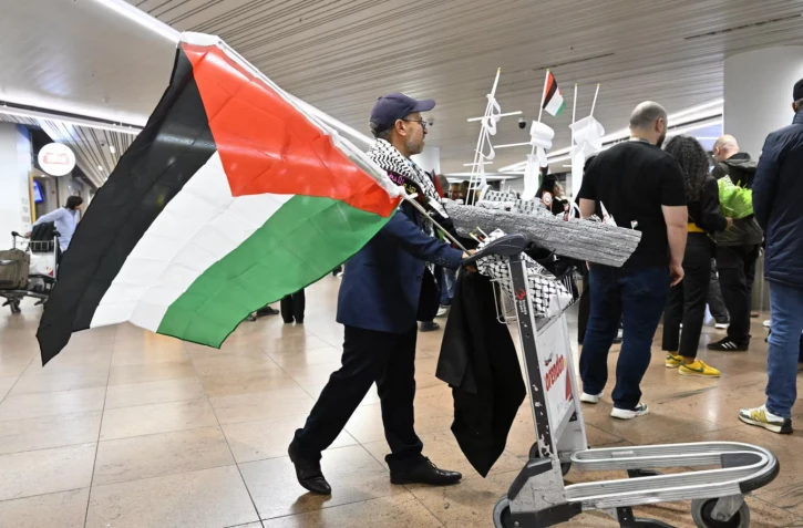 Un drapeau palestinien à l'arrivée à l'aéroport de Bruxelles des membres belges de la flottille pour Gaza, le 7 octobre 2025. (ERIC LALMAND / BELGA MAG / VIA AFP)