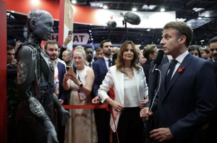   Le président Emmanuel Macron regarde le robot humanoïde Ameca d'IVADO Labs lors de sa visite au salon VivaTech, le 11 juin 2025 à Paris POOL/AFP Sarah Meyssonnier