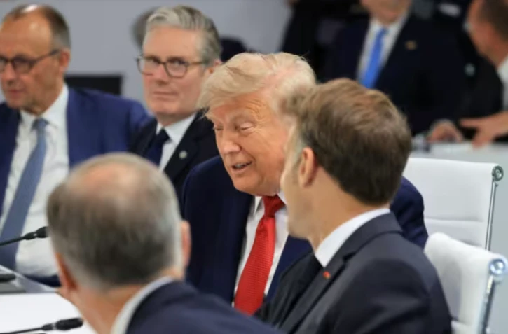 Le chancelier allemand Friedrich Merz, le Premier ministre britannique Keir Starmer, le président américain Donald Trump et le président français Emmanuel Macron au sommet du G7, à Évian, le 17 juin 2026 ( AFP / Ludovic MARIN )