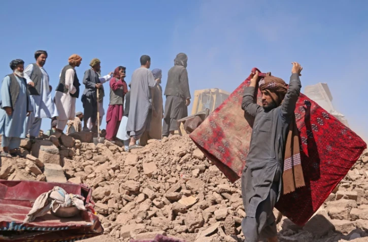 Des habitants dans les décombres de maisons détruites par un tremblement de terre à Zenda Jan, le 9 octobre 2023 dans la province de Hérat, en Afghanistan
