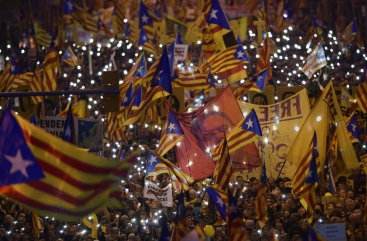 Des manifestants brandissent des drapeaux catalans et le portrait d'Oriol Junqueras, l'ex-vice-président de Catalogne, le 16 février 2019 à Barcelone