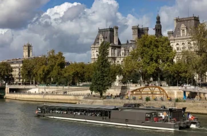 Un bateau mouche qui navigue sur la Seine, passe devant l'Hôtel de Ville de Paris, le 5 octobre 2025 ( AFP / JOEL SAGET )