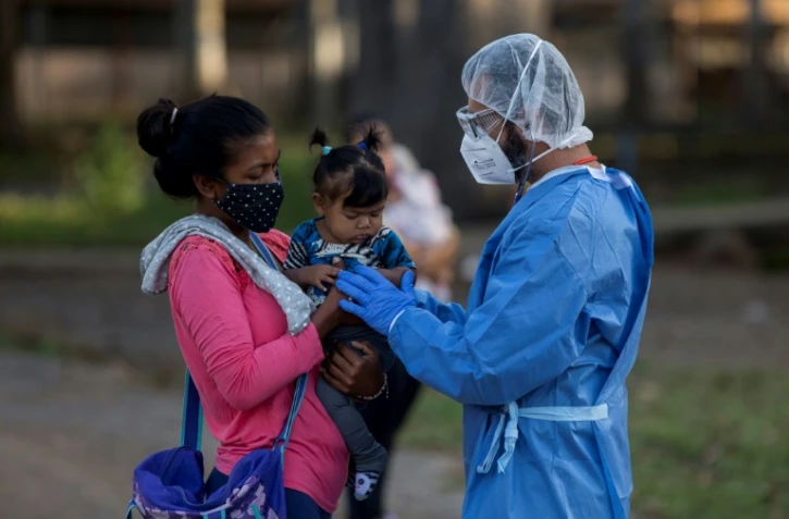 Un médecin du centre de santé de Médecins sans frontières (MSF) reçoit en consultation une femme et son bébé, le 17 mars 2021 à Vidoño, au Venezuela