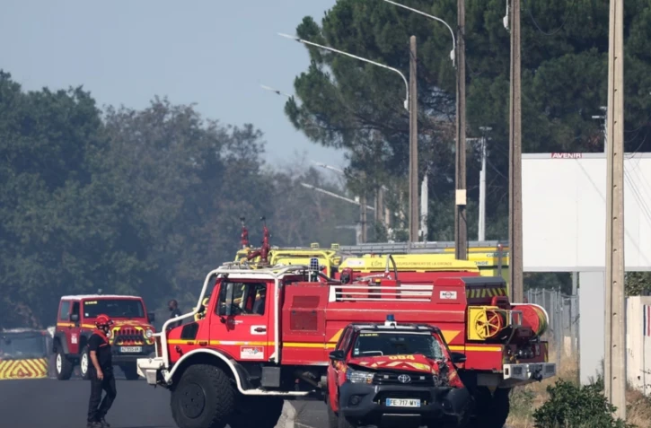 Des camions de pompiers sont stationnés devant un bâtiment où un incendie s’est déclaré et où deux pompiers ont trouvé la mort en combattant le feu, à Mérignac, non loin de l’aéroport de Bordeaux-Mérignac, le 21 juillet 2026. | AFP