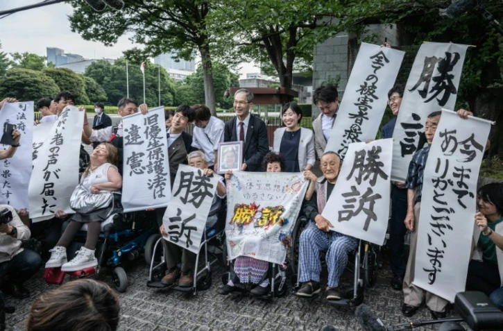 Des victimes de stérilisation forcée célèbrent avec des avocats et des sympathisants la décision de la Cour suprême du Japon, le 3 juillet 2024 à Tokyo