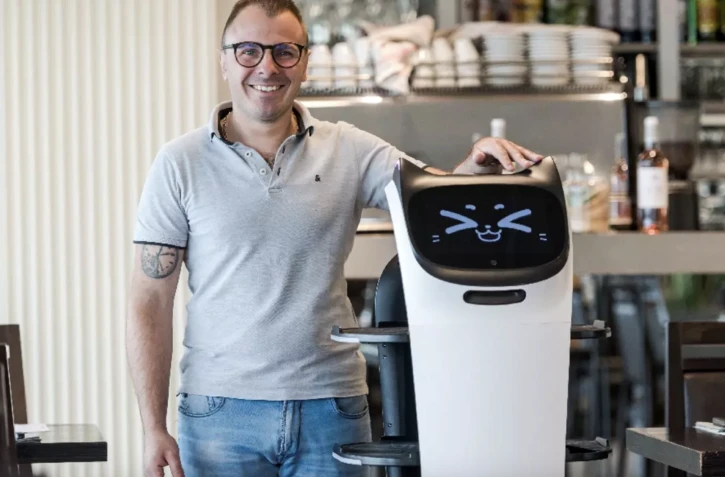  Geoffrey Ruamps, directeur du restaurant le Cap 180, pose avec le robot serveur "Bella" dans son restaurant, à Cieurac, dans le Lot, le 14 mai 2024 AFP / Matthieu RONDEL 