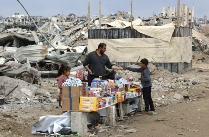 Un épicier derrière son stand, dressé au milieu des ruines de Jabalia, dans le nord de la bande de Gaza, le 5 février 2025 ( AFP / Omar AL-QATTAA )