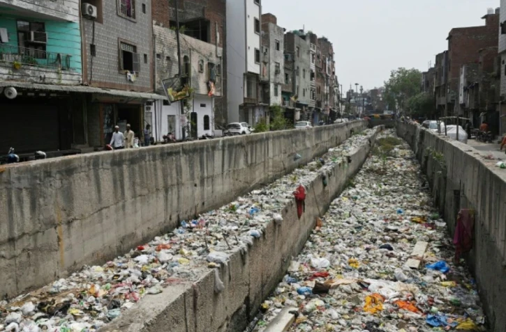 Un égout pluvial rempli d'ordures à Seelampur, quartier de New Delhi, le 26 avril 2023 ( AFP / Arun SANKAR )