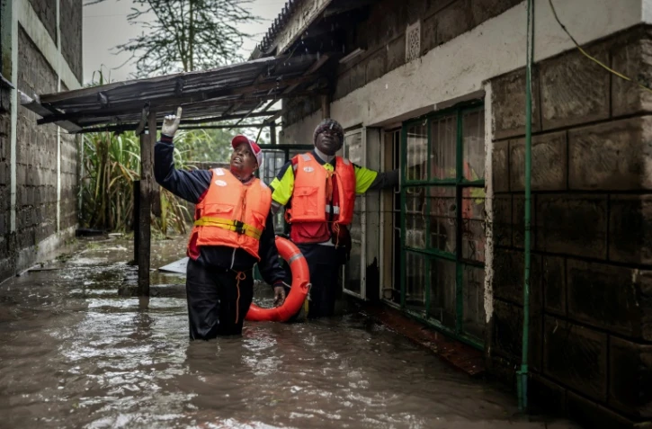 Des membres de la Croix-Rouge recherchent dans une zone inondée des habitants piégés dans leurs maisons après des pluies torrentielles à Kitengela, le 1er mai 2024 au Kenya