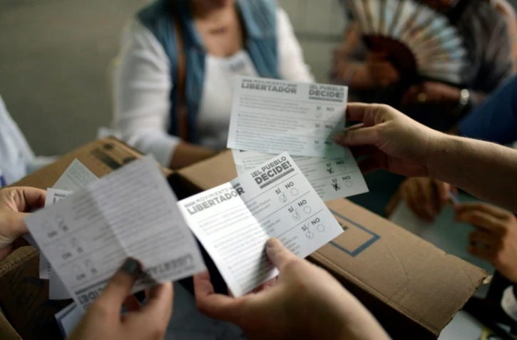 Des bénévoles comptent les bulletins le 16 juillet 2017 lors de la consultation symbolique organisée par l'opposition contre le président Nicolas Maduro et son projet d'Assemblée constituante 