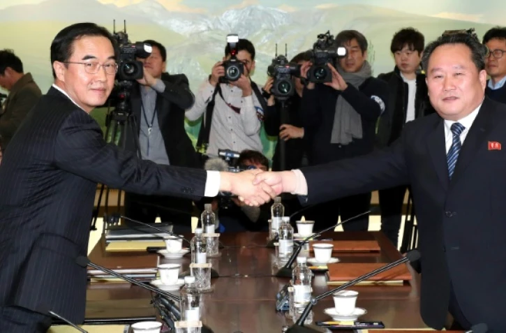 Le ministre sud-coréen de l'unification Cho Myung-Gyun (g) serre la main du responsable de la délégation nord-coréenne Ri Son-Gwon (d) lors d'une rencontre à Panmunjom, le 9 janvier 2018