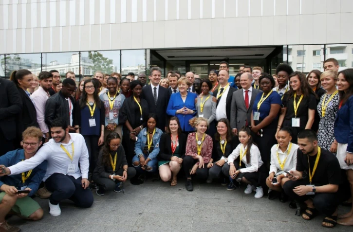 Emmanuel Macron et Angela Merkel posent avec des étudiants lors d'une visite de l'Office franco-allemand de la Jeunesse, le 13 juillet 2017