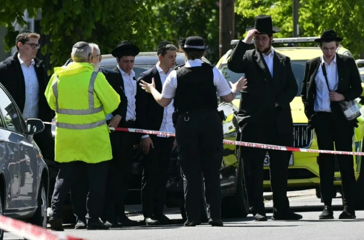 Des habitants derrière un périmètre de sécurité établi dans le quartier de Golders Green, au nord de Londres, le 29 avril 2026, après l'agression au couteau de deux personnes
