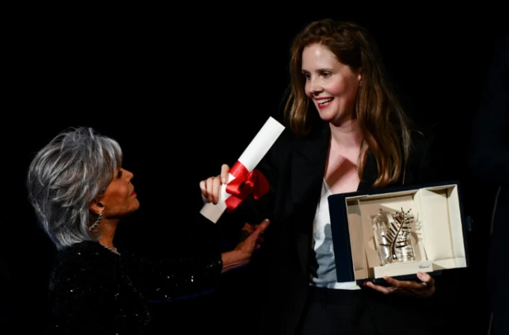La réalisatrice française Justine Triet (d) reçoit la Palme d'or du 76e Festival de Cannes, des mains de l'actrice américaine Jane Fonda, pour "Anatomie d'une chute", le 27 mai 2023