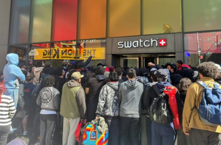 Des personnes attendent pour entrer dans une boutique Swatch à Time Square pour la sortie de la montre Audemars Piguet Swatch "Royal Pop", le 16 mai 2026 à New York