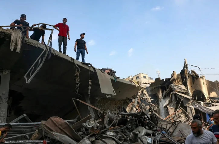 Les gens vérifient les destructions après des frappes israéliennes sur le camp de réfugiés de Chati dans la ville de Gaza le 28 octobre 2023