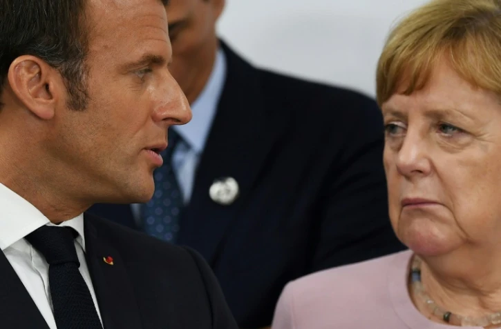 Le président français Emmanuel Macron et la Chancelière allemande Angela Merkel discutent lors du sommet du G20 à Osaka, le 29 juin 2019.