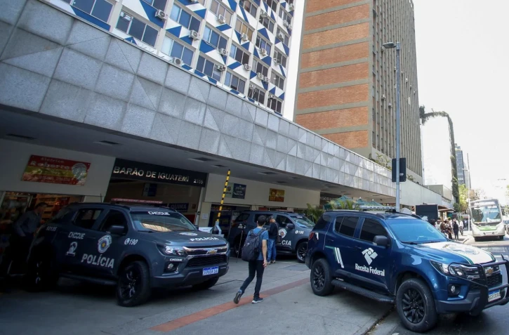 Des véhicules de police sont garés devant un bâtiment du centre financier de l'avenue Faria Lima à Sao Paulo, au Brésil, le 28 août 2025. La police brésilienne a lancé jeudi une vaste opération contre un vaste réseau de blanchiment d'argent impliquant le crime organisé et le secteur financier, ont annoncé les autorités. (Photo de Miguel SCHINCARIOL/AFP) - M. Schincariola/AFP