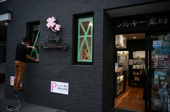 un homme barricade une pharmacie avant l'arrivée du cyclone Haishen à Kagoshima au Japon le 5 septembre